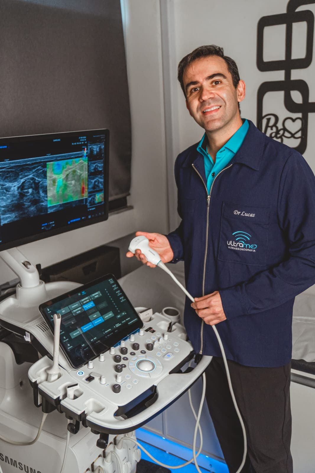 Dr. Lucas Miranda Zucchetto com o aparelho de ultrassom na sala de exames da Ultramed